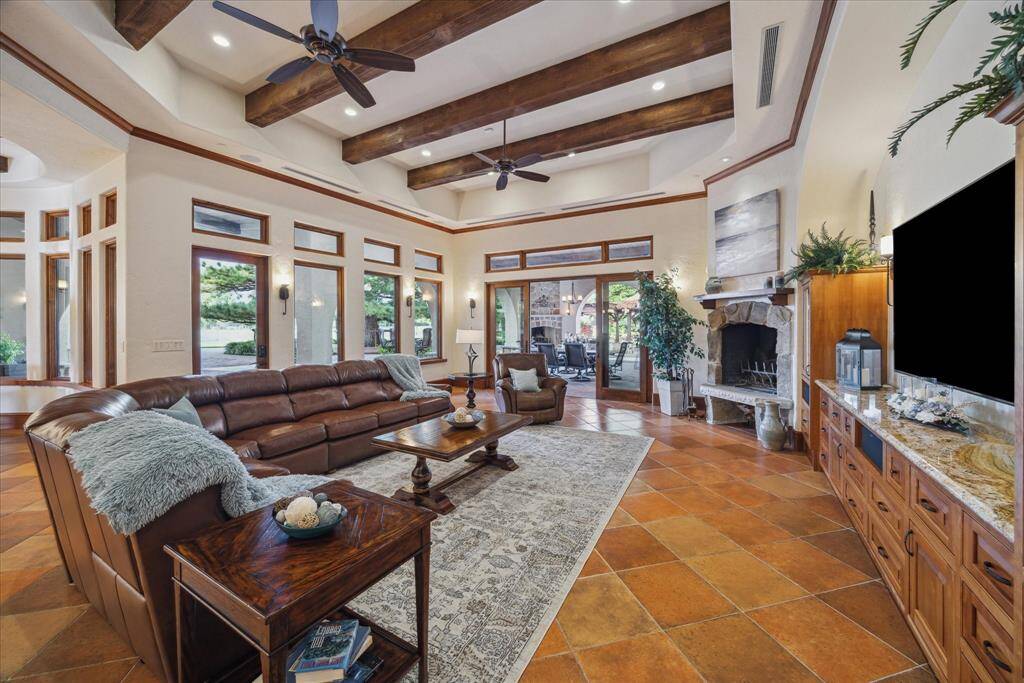An oversized, natural stone wood-burning fireplace and hearth create ambiance. Built-in drawers and cabinetry accommodate media equipment and store books and games for family fun. The large arch crafts a natural focal point in the room-no screen is too large.