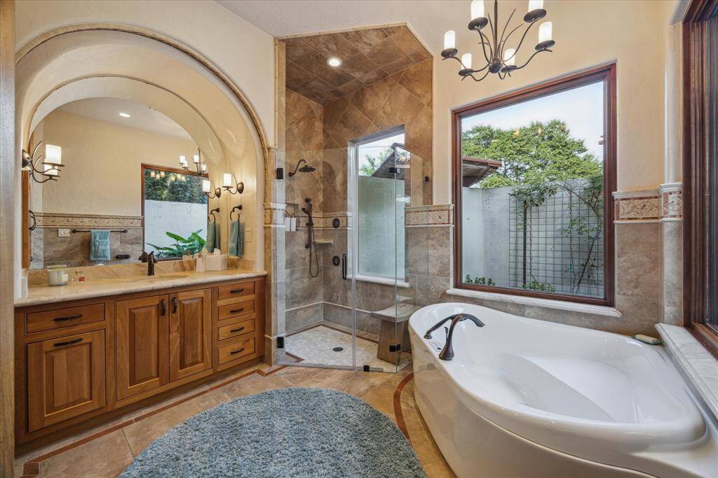 The dedicated en-suite bathroom rivals any primary bath with three large windows overlooking the private garden. Nestled under the windows is a Bain Ultra air jetted and warming tub as well as a separate seamless rain shower with handheld sprayer and four additional spray heads. The custom, solid wood built-in vanity boasts abundant marble countertop space and arched mirror.