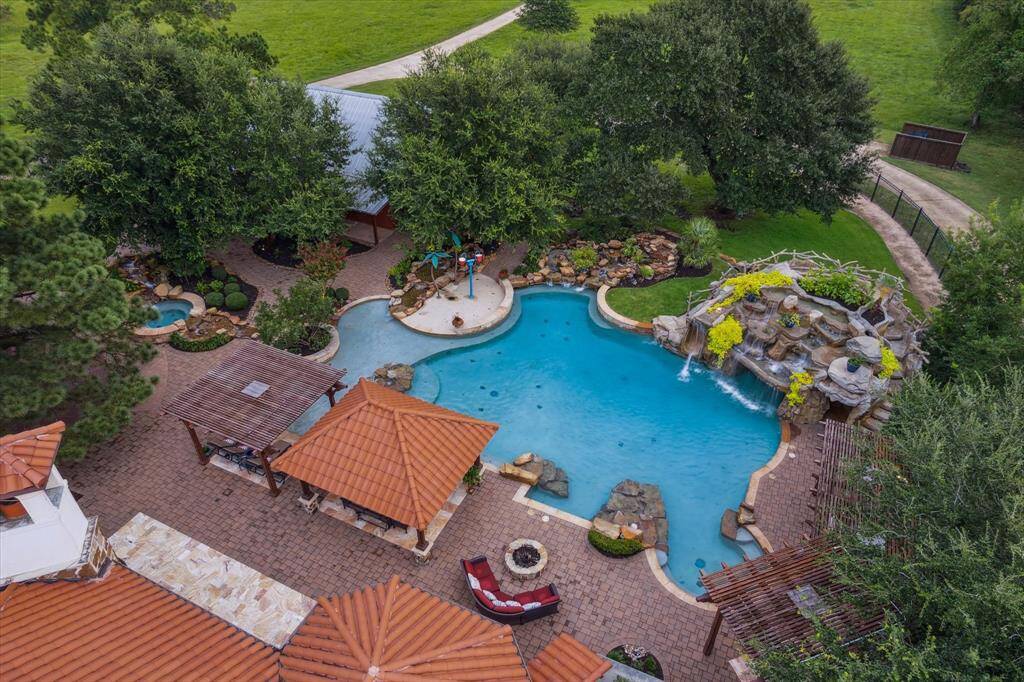 A series of arbors and cabanas create an unrivaled retreat atmosphere. The slide, splash pad, grotto, hot tub and waterfall make guests, both young and old, feel like they are on vacation and regularly provide hours of fun and enjoyment in your own private backyard.