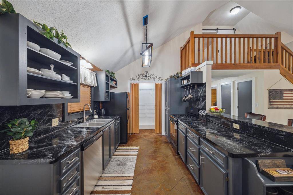 A breakfast area is just off the galley kitchen featuring stainless steel appliances, gas range and a washer and dryer. The kitchen sink is nestled below a large window with a view of the property.