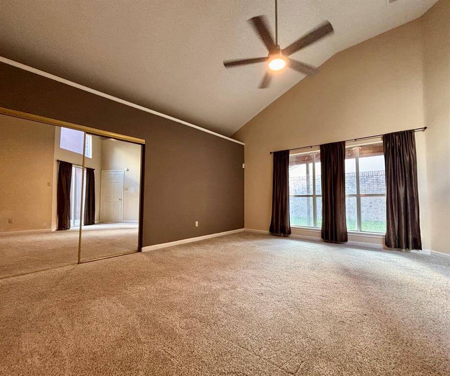 A spacious primary bedroom with a door that opens to a beautiful atrium.