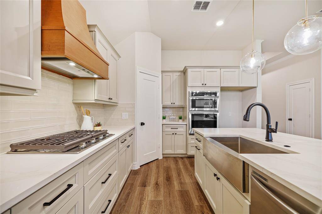 Built in appliances with custom wood hood.  Check out that farm house sink!