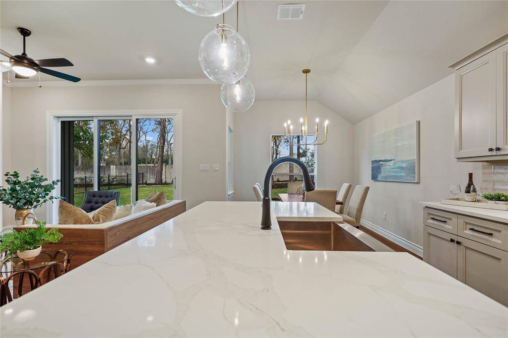 Quartz countertops, farm house sink, & pullout kitchen faucet with disposal switch on the countertop.