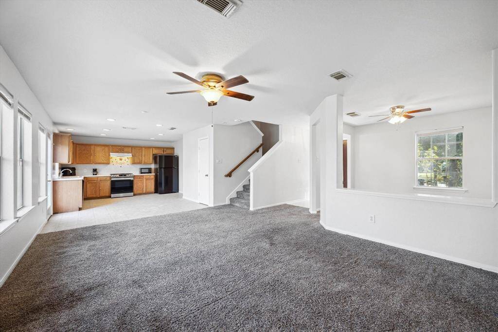 Living room with a view to the kitchen, breakfast area, and formal dining or study.