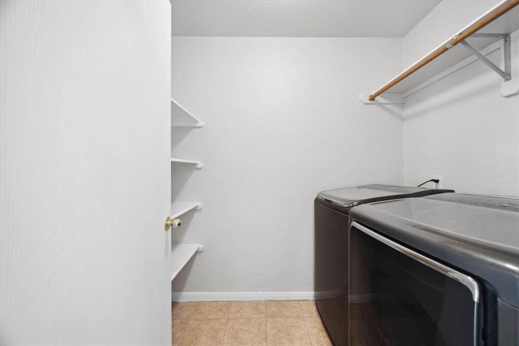 Large laundry room with shelving for extra storage.