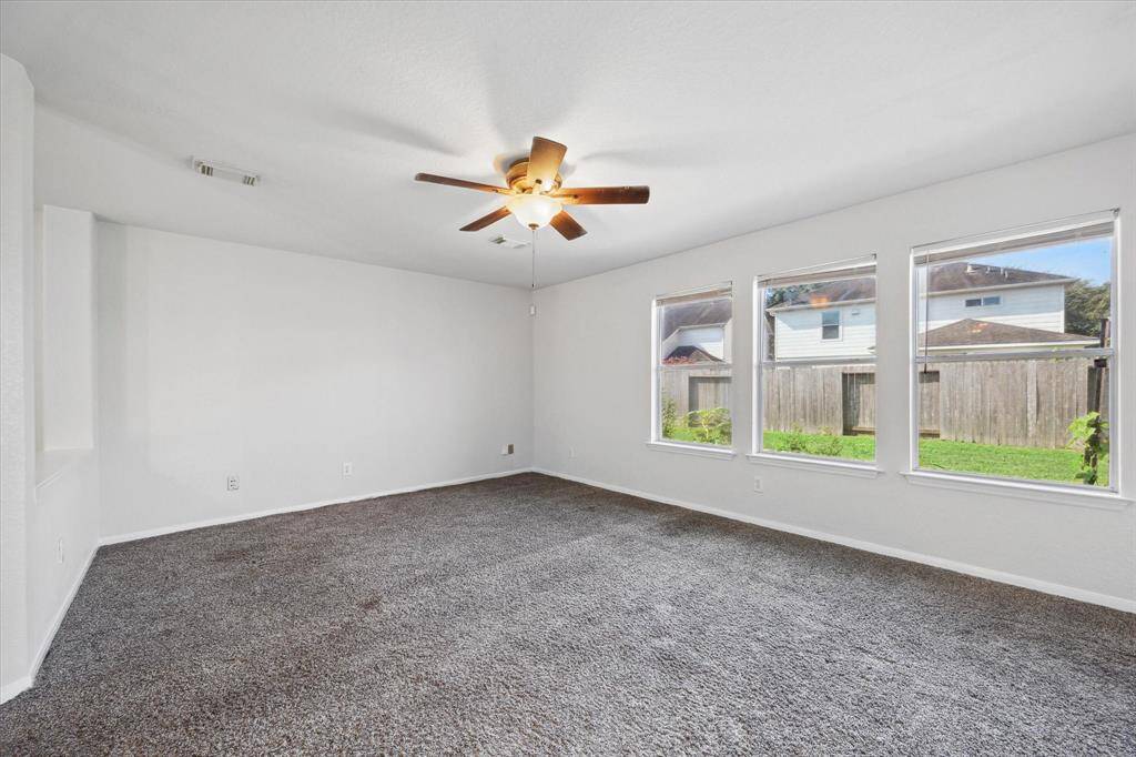Living room overlooks the large backyard and opens up to the kitchen and dining areas.