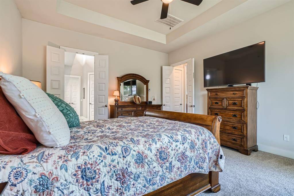 Another view of the primary suite with tray ceilings