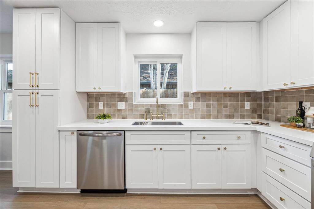 THE GOURMET KITCHEN HAS BEEN PROFESSIONALLY DESIGNED WITH WHITE SHAKER CABINETS, QUARTZ COUNTERS, LARGE UNDER-MOUNT SINK AND TRENDY CUSTOM BACK-SPLASH.