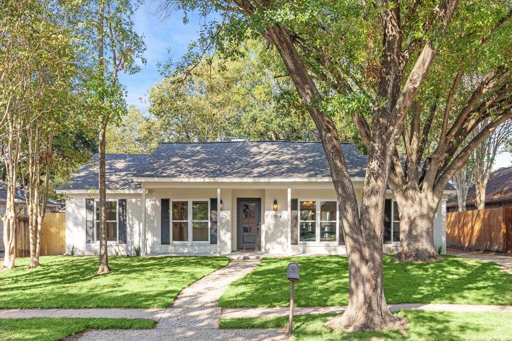 STUNNING 1-STORY HOME WITH DECORATIVE SHUTTERS, HANDSOME FRONT DOOR AND METICULOUS FRONT YARD WITH MATURE TREES.