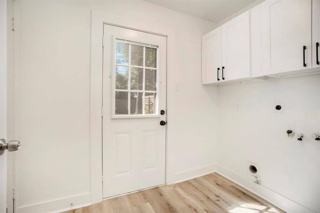 Convenient laundry room with ample cabinetry and direct outdoor access.