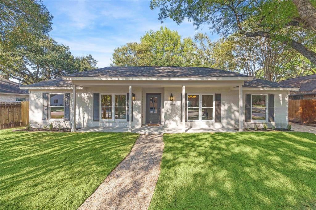 LARGE FRONT YARD WITH LUSH GREEN GRASS AND RECENT LANDSCAPING.