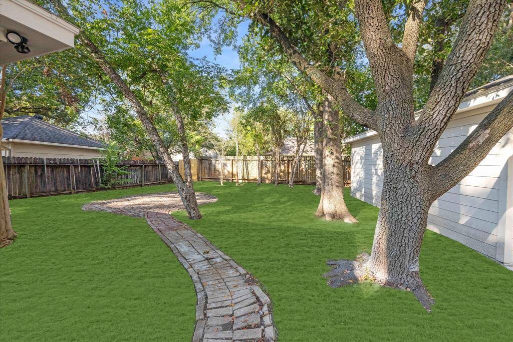 THE BACKYARD IS SPACIOUS WITH MATURE TREES.