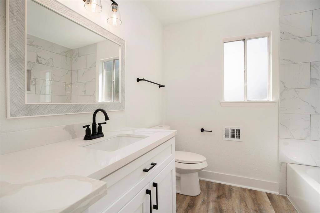 Elegant upstairs secondary bathroom with a sleek tub/shower combination.
