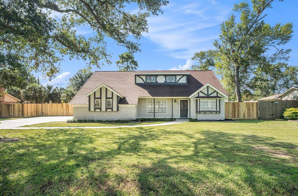This is a two-story suburban home with a fresh, modern exterior, featuring a combination of brick and siding. It has a spacious driveway, a large fenced yard, and mature trees that provide a cozy, established neighborhood feel.