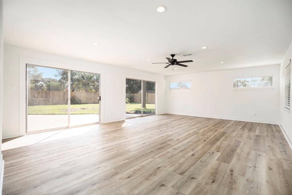 Inviting family room with seamless indoor-outdoor flow, featuring dual sliding doors opening onto a sunny patio and expansive backyard.