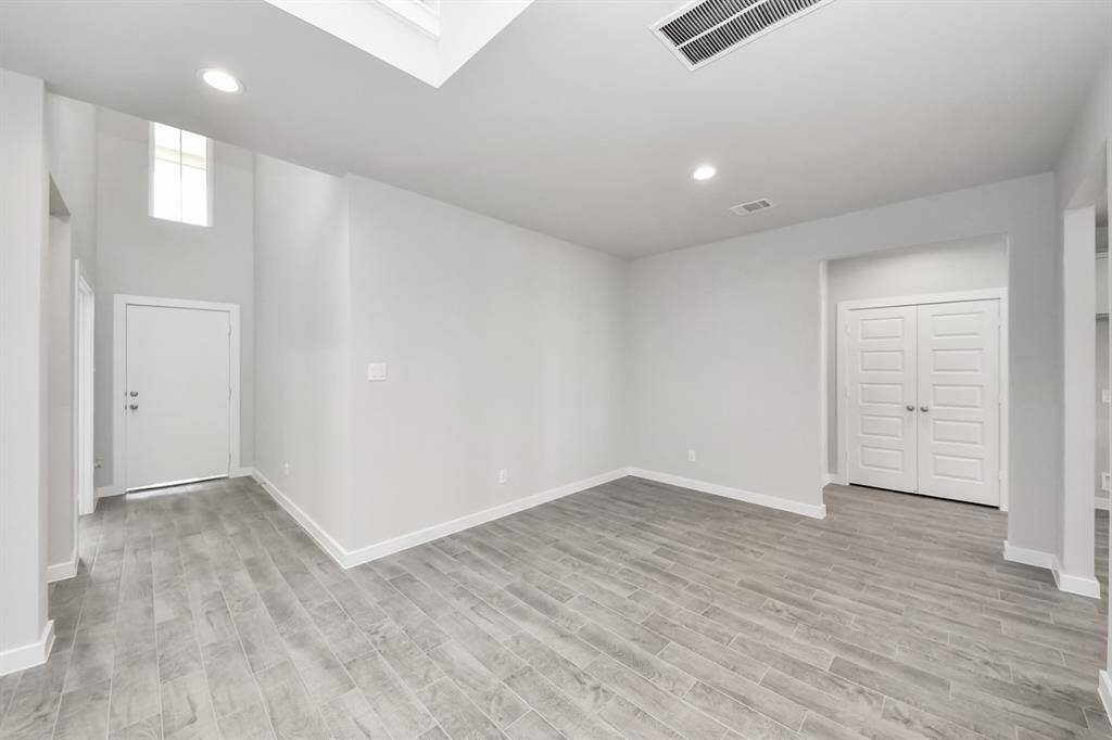 Welcome family and guests to your charming living room! With its high ceilings, recessed lighting, ceiling fan, custom paint, beautiful flooring, and large windows that let in abundant natural light, this room is perfect for gatherings.