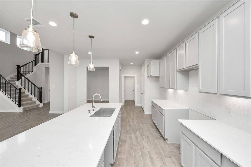 Escape and relax in the exquisite primary suite, a haven to unwind after a long day. The spacious room, located on first floor, boasts plush carpeting, soothing paint tones, high ceilings, and expansive windows adorned with privacy blinds.