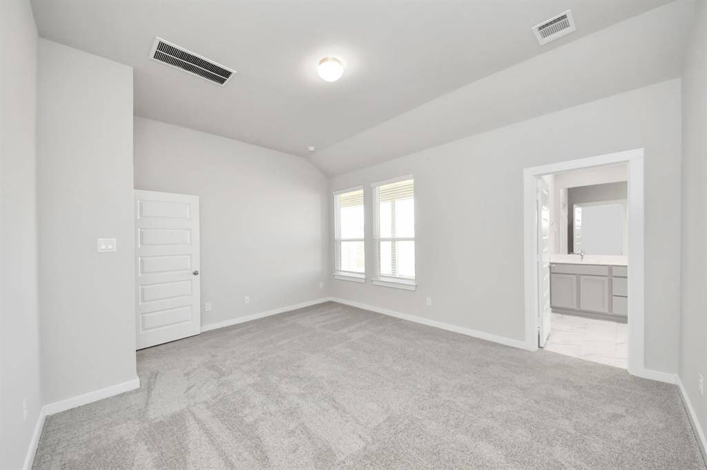 Retreat to the luxurious primary suite, your perfect escape for unwinding after a long day. Located on the first floor, this spacious room features plush carpeting, calming paint tones, high ceilings, and large windows with privacy blinds.
