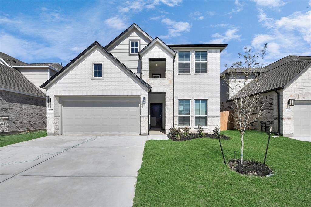 The residence features a practical 2-car garage complemented by a generous driveway, ensuring abundant space for parking needs.