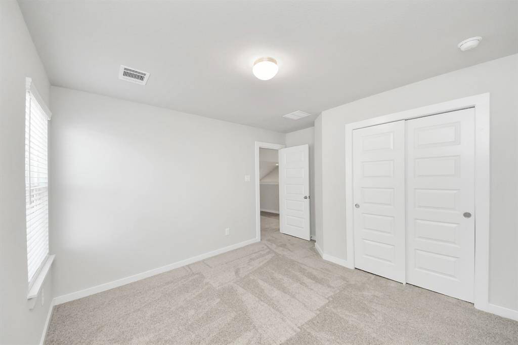 Secondary bath features tile flooring, bath/shower combo with tile surround, light stained wood cabinets, beautiful light countertop.