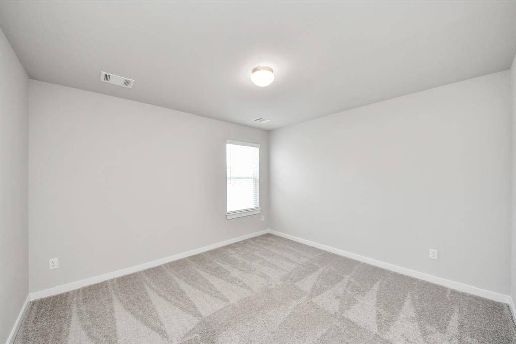 Secondary bedroom features plush carpeting, large windows that let in plenty of natural light, bright paint, and spacious closets.