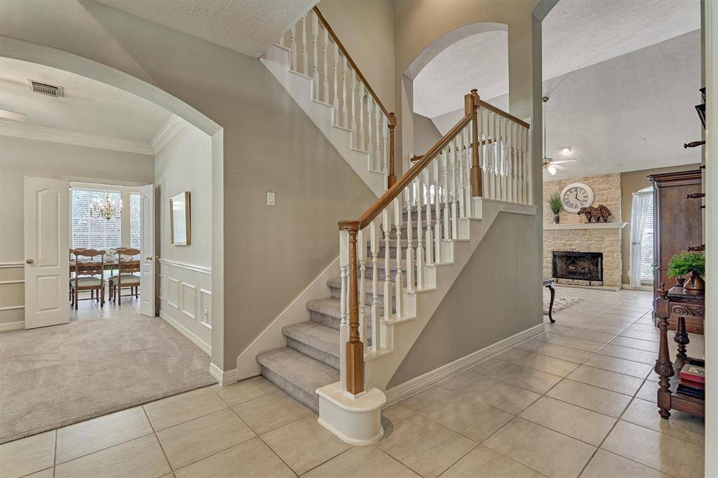 Staircase winds up to balcony overlooking foyer and living areas