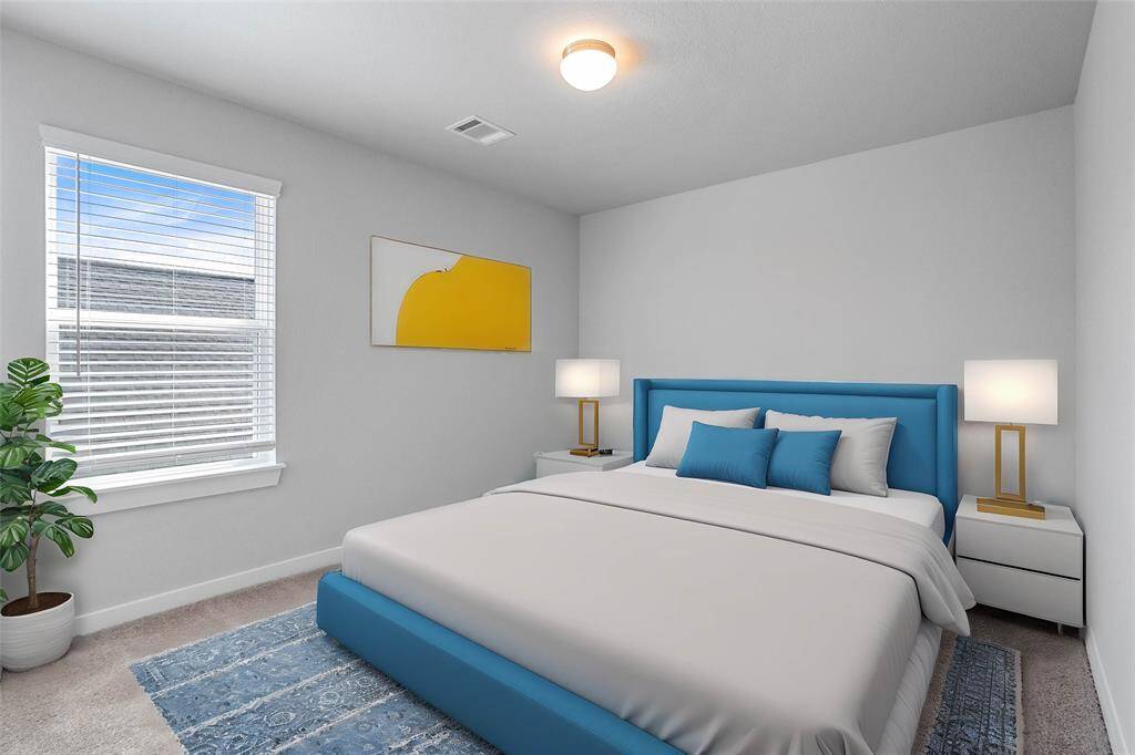 Secondary bedroom features plush carpet, neutral paint and a large window with privacy blinds.