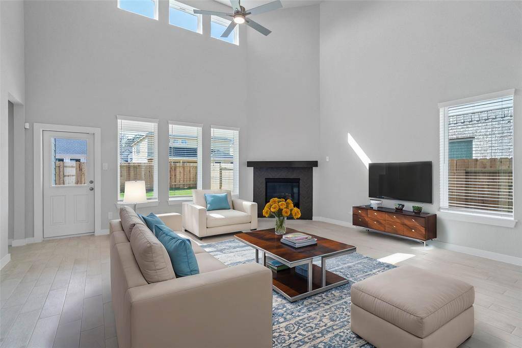 Gather the family and guests together in your lovely family room! Featuring a stunning fireplace with wood mantel, high ceilings with ceiling fan, custom paint, gorgeous wood look tile floors and large windows that provide plenty of natural lighting throughout the day.