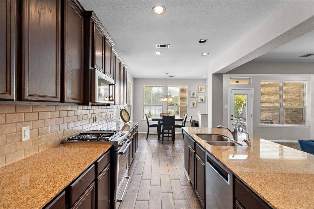 The kitchen features stainless steel appliances with a gas range.