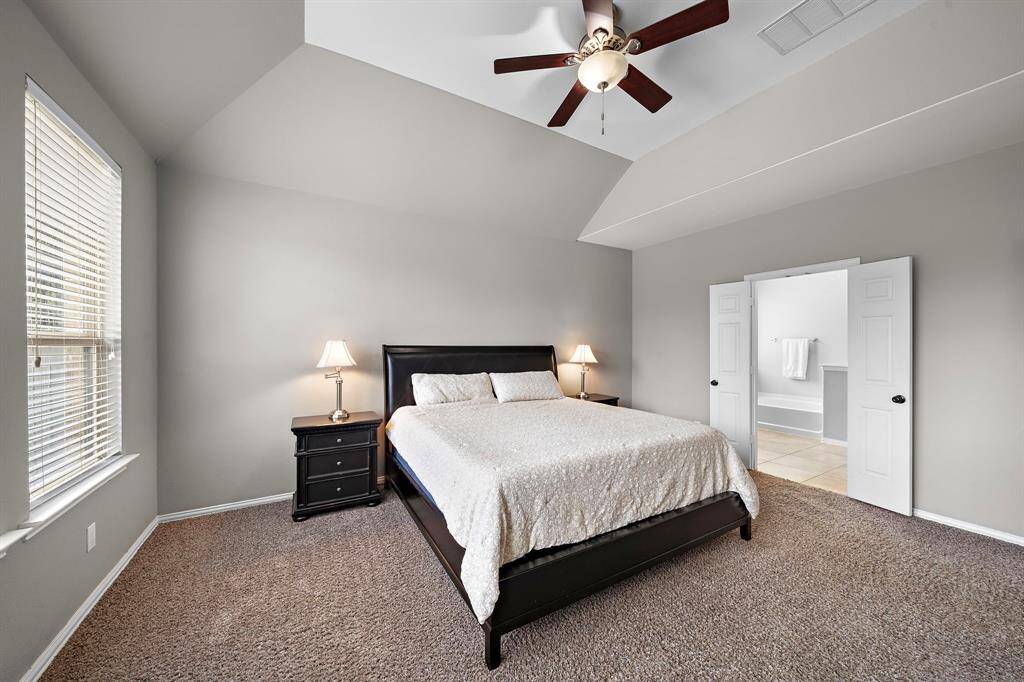 Beautiful primary suite features tall ceilings and an en suite bathroom.