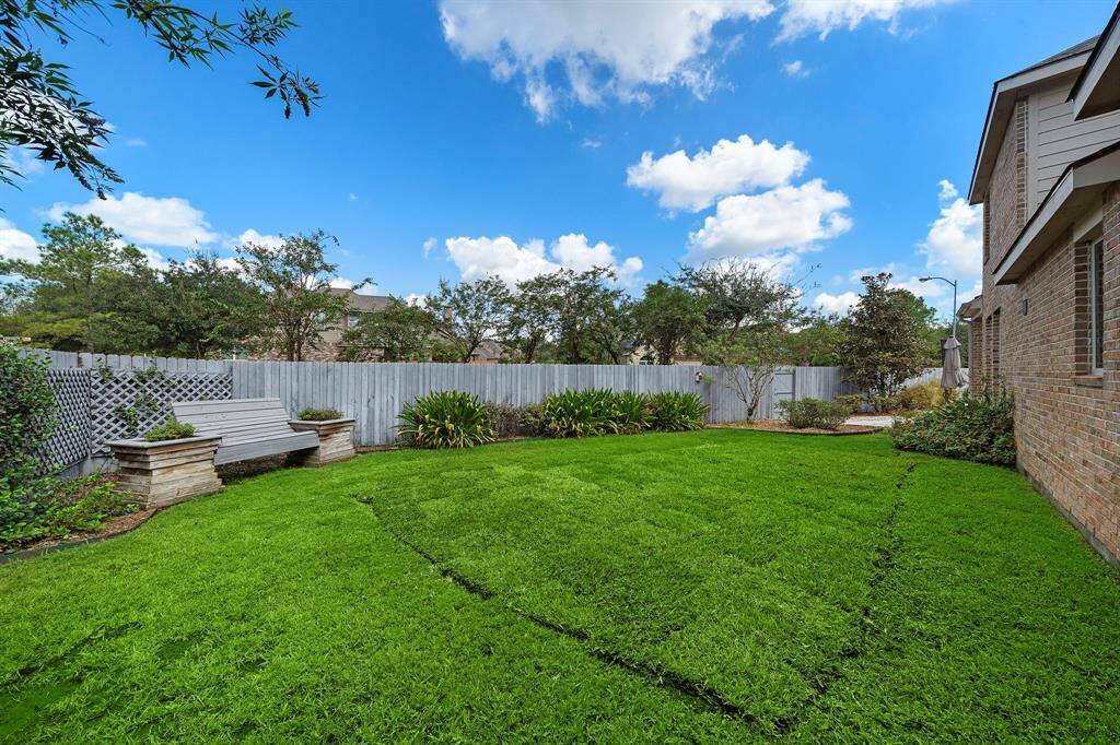 Large side yard featuring a custom bench and landscaping.