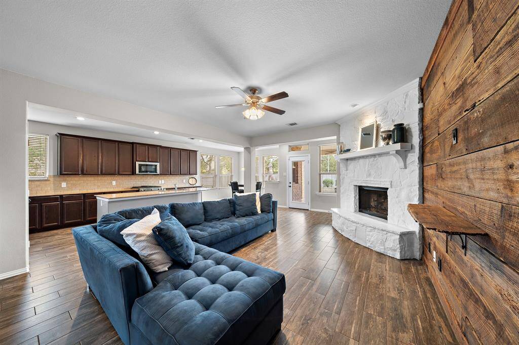 The living room features a stone fireplace and mantel, as well as a custom wood wall.