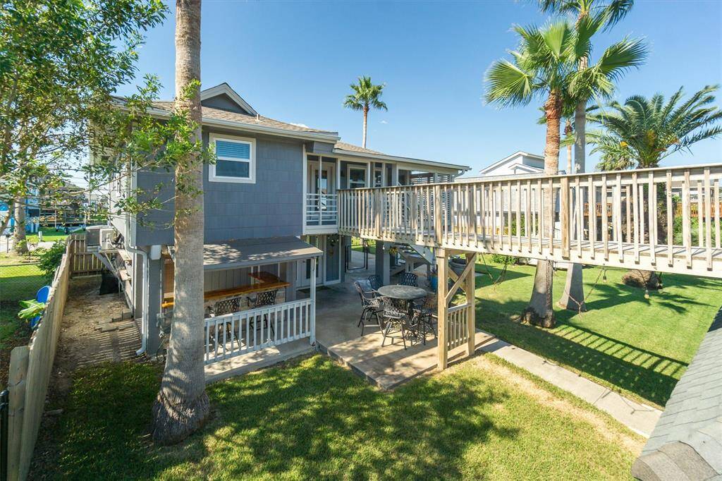 View from the upper party deck towards the home. Notice the custom bar downstairs and the extra entertaining space!