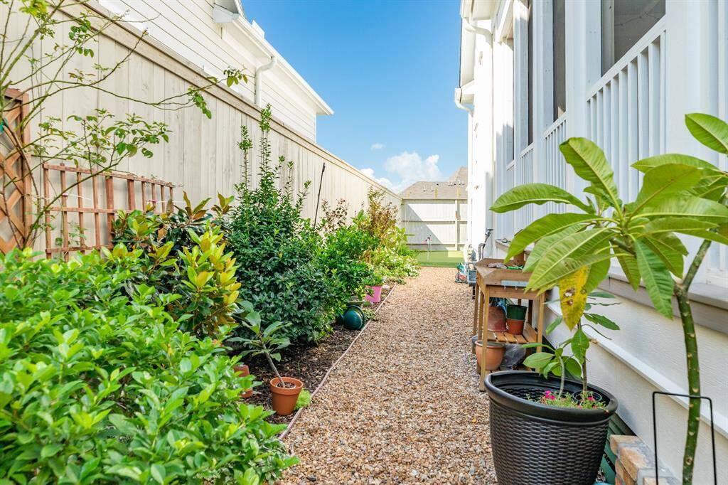 Well-maintained side yard with gravel walkway is perfect for those with a green thumb.