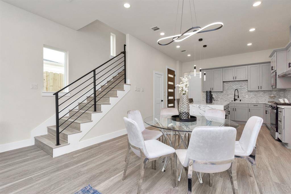 Living Room/Dinning Room with wrought iron staircase design.