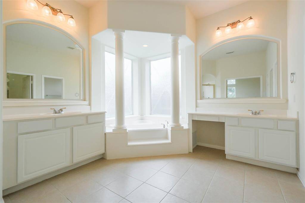 Soaking tub in a large primary bedroom offers relaxation after a long day work.