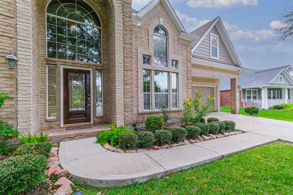 A charming front door with elegant overhead glass windows, allowing natural light to filter in, enhances the home's inviting entrance.
