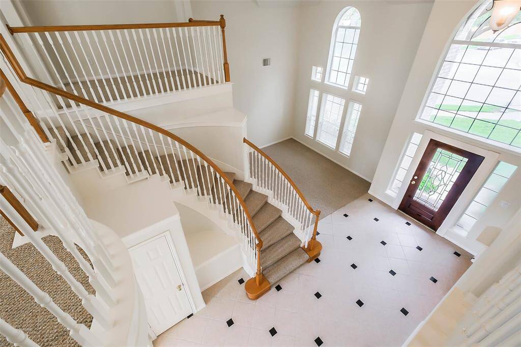 Front entrance with high ceilings offers openness and elegance to visitors, creating an inviting and airy atmosphere upon arrival