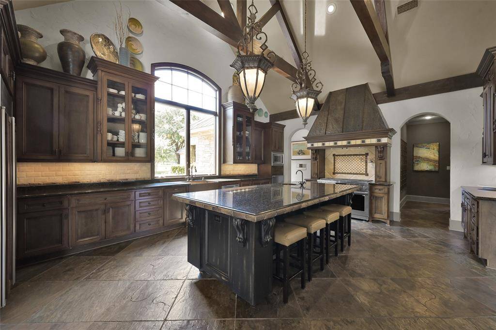 Gourmet kitchen with massive island, custom cabinetry, professional appliances and ample storage.