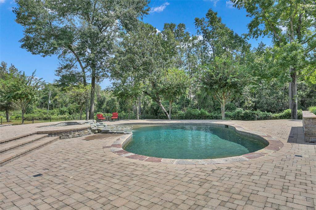 The heated pool and spa, complete with a waterfall feature, add beauty and the soothing sound of water to your backyard oasis.
