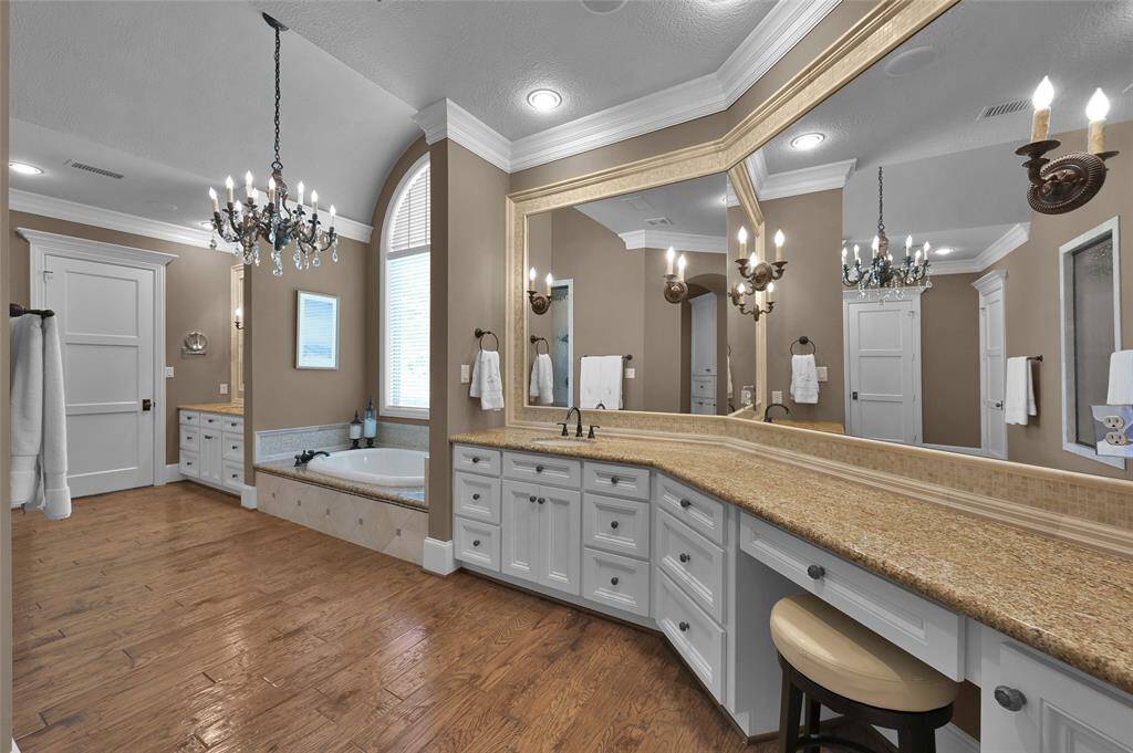 Primary bathroom features dual vanities and separate closets with built ins.