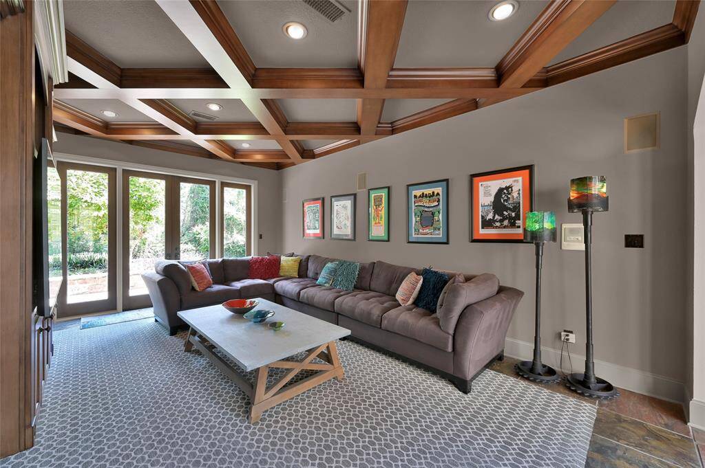 Gameroom with coffered ceiling and built in custom cabinetry. French doors open to the backyard.