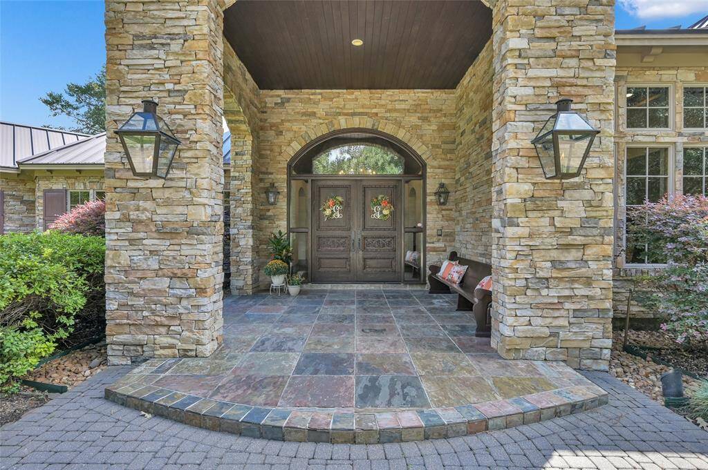 Step onto the inviting covered front porch, featuring elegant gas lanterns, as you make your way to the impressive solid wood double doors.