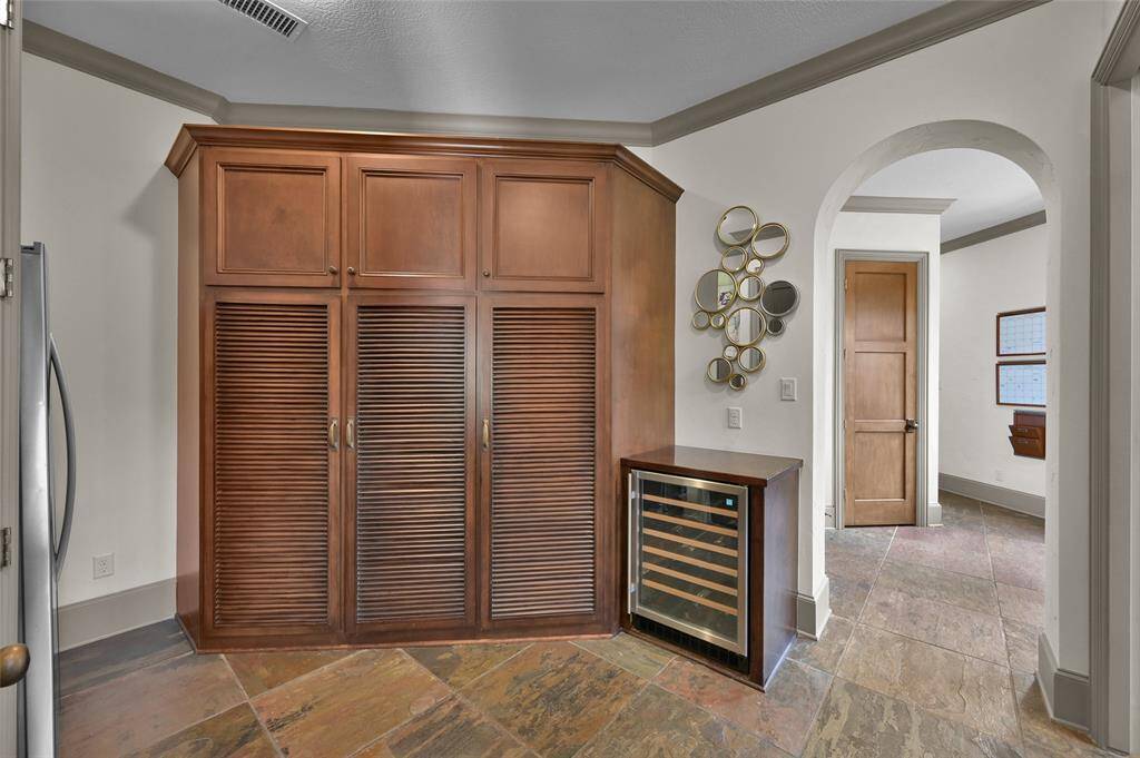 Another view of mudroom. Wine refrigerator is brand new (2024). Door in background is a full size staircase leading to expansive attic.