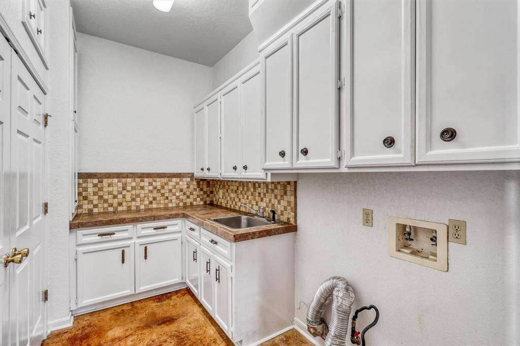 Laundry Room with sink, closet and cabinets. Laundry chute from the 2nd floor.