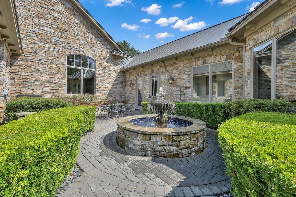 This beautiful fountain brings tranquility to the courtyard nestled between the home and the motor court.