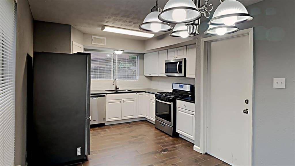 Modern kitchen outfitted with sleek stainless steel appliances, including a microwave, range, and refrigerator, all ready for your culinary adventures.