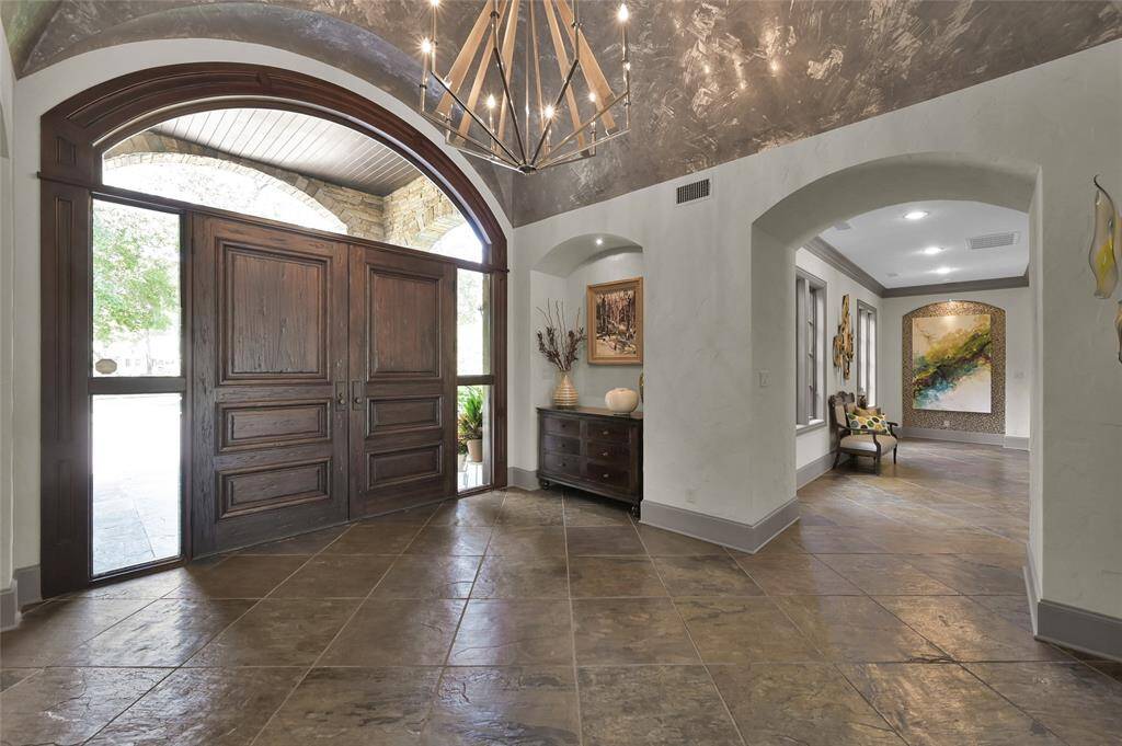 Elegant gallery hallway off foyer leads to home office and primary suite.