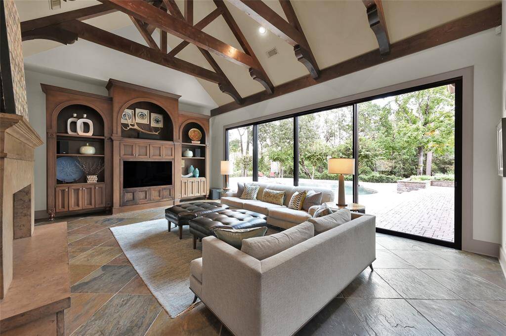 Family Room with cathedral ceilings, exposed wood trusses, custom built-in cabinetry and glass slider doors for seamless outdoor access.