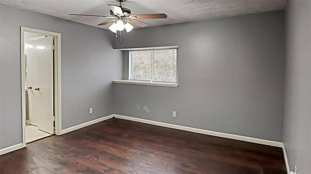 Spacious Master Retreat with Elegant Hardwood Floors and Ample Natural Light.